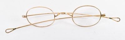 Lot 860 - A pair of yellow metal spectacles, marked...