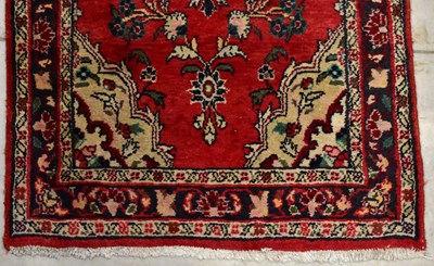 Lot 95 - A modern runner with floral patterns on a red ground