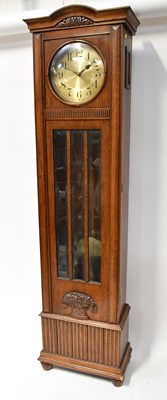 Lot 129 - A 1930s oak longcase clock, the...