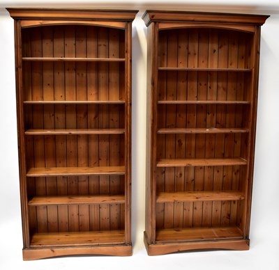 Lot 82 - A pair of waxed pine tall bookcases of six...