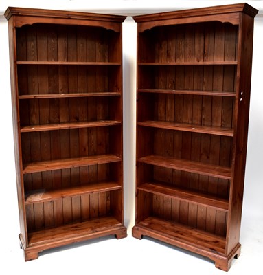 Lot 84 - Three matching waxed pine tall bookcases of...