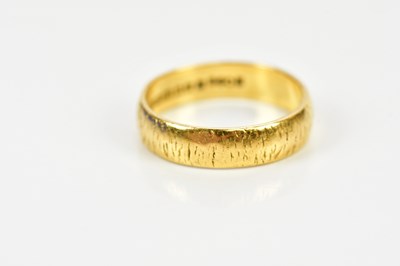 Lot 100 - A 22ct yellow gold textured wedding band, size...