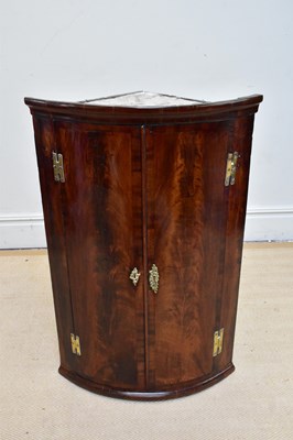 Lot 1128 - A Georgian mahogany hanging bowfront corner...