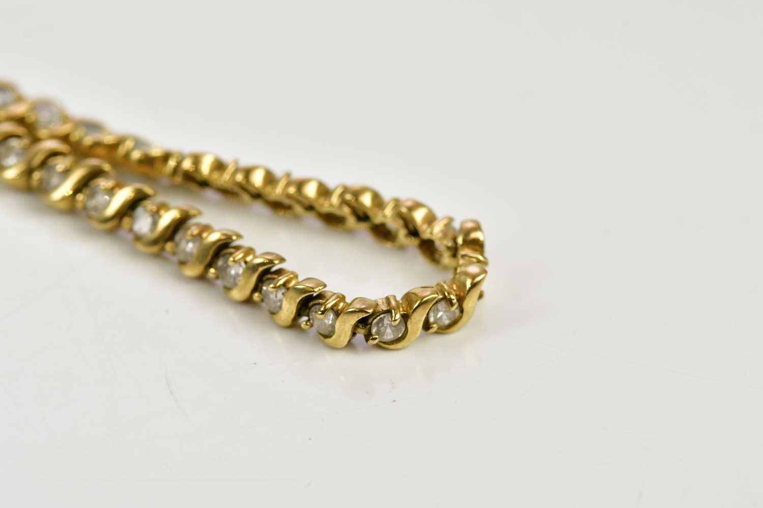 Lot 445 - A 9ct yellow gold line bracelet set with