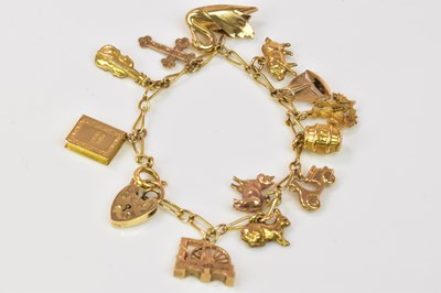 Lot 1256 - A 9ct yellow gold charm bracelet set with...