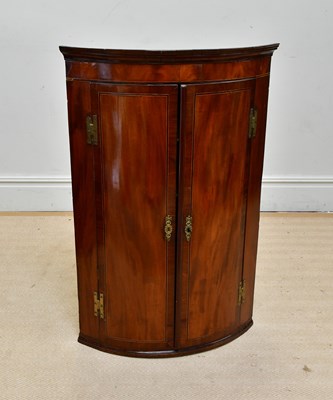 Lot 1050 - A George III mahogany bowfront hanging corner...
