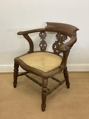 Lot 831 - An elm captain's chair with rattan caned seat.