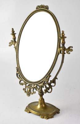 Lot 130 - An oval brass swing mirror on a pedestal base,...