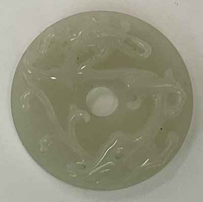 Lot 267 - A Chinese jade bi disc, with carved relief...