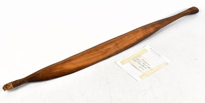 Lot 1030 - An Aboriginal carved wood woomera/spear thrower, length 81cm, with a note on the back of card from Bellamy's Aboriginal Art Gallery, Freemantle (2)