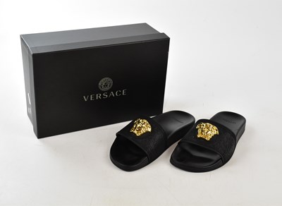 Lot 930 - VERSACE; a pair of black rubber sandal sliders...