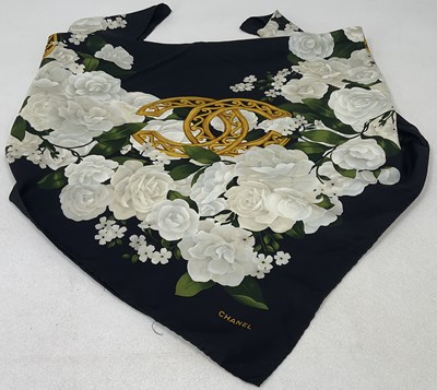 Lot 83 - CHANEL; a silk scarf with white floral design...