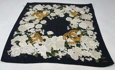 Lot 83 - CHANEL; a silk scarf with white floral design...