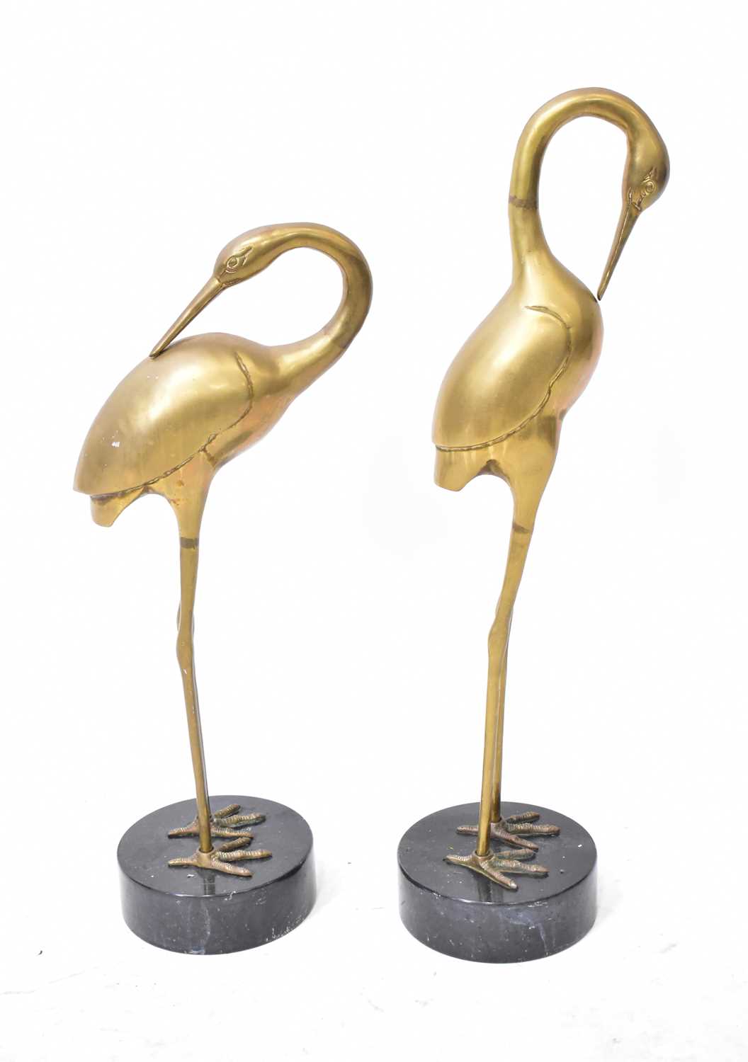 Lot 545 - A pair of brass statues of cranes, each with...