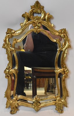 Lot 46 - A decorative ornate gilt framed wall mirror,...