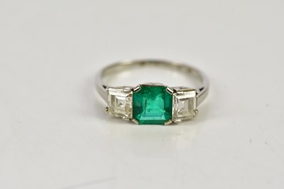 Lot 38 - A platinum emerald and diamond three stone...