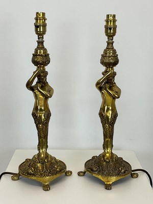 Lot 727 - A pair of brass table lamps in the form of a...