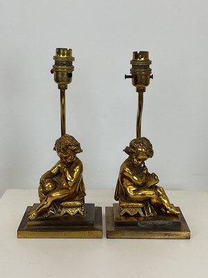 Lot 728 - A pair of gilded brass table lamps in the form...