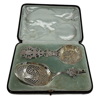 Lot 1139 - Two cased white metal ornately decorated and...