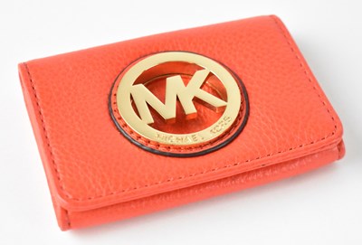 Lot 554 - MICHAEL KORS; a red leather purse with gold...