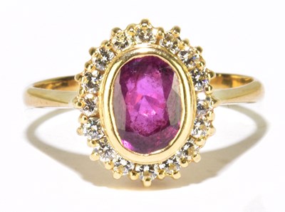 Lot 1043 - An 18ct yellow gold ruby and diamond oval ring,...