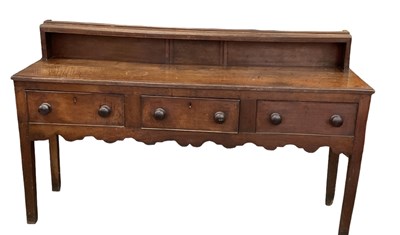 Lot 7 - An early 19th century English oak three drawer...