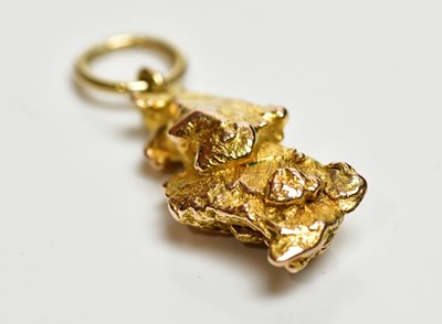 Lot 1202 - A yellow metal nugget pendant, with simple...