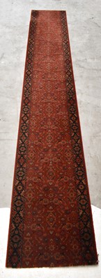 Lot 2676 - A large Eastern runner with floral detail on a...