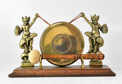 Lot 435 - A small brass tabletop dinner gong held aloft...