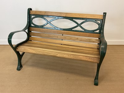 Lot 746 - A modern garden bench with cast metal ends and...