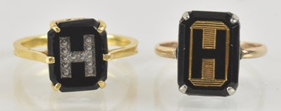 Lot 1331 - A yellow metal and onyx set 'H' ring, size M,...