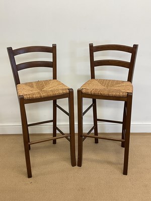 Lot 879 - A pair of wooden counter stools with rush...