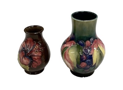 Lot 654 - MOORCROFT; a green ground vase, decorated in...