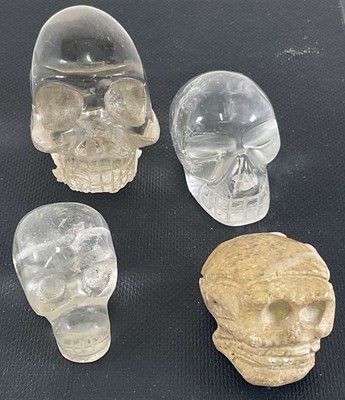 Lot 1044 - Three small carved crystal skulls, the largest...