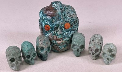 Lot 1034 - A group of six small carved green stone skulls,...