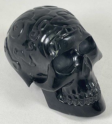 Lot 1046 - A large black skull with patterned detail to...