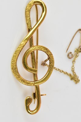 Lot 1229 - An 18ct yellow gold treble clef brooch, length...