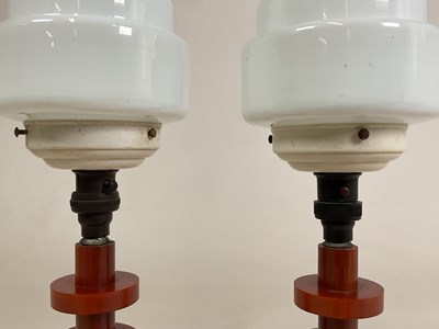 Lot 720 - A pair of amber bakelite Art Deco lamps with...