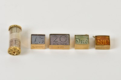 Lot 1225 - Five 9ct gold cased charms, containing faux...