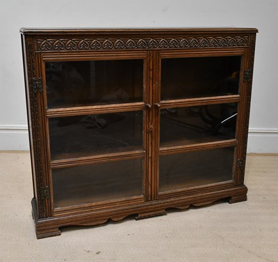 Lot 99 - A reproduction carved oak two door bookcase,...