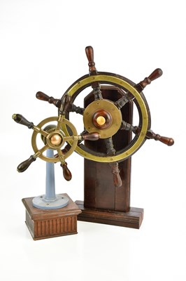 Lot 307 - Two brass ship's wheels, mounted on wooden...