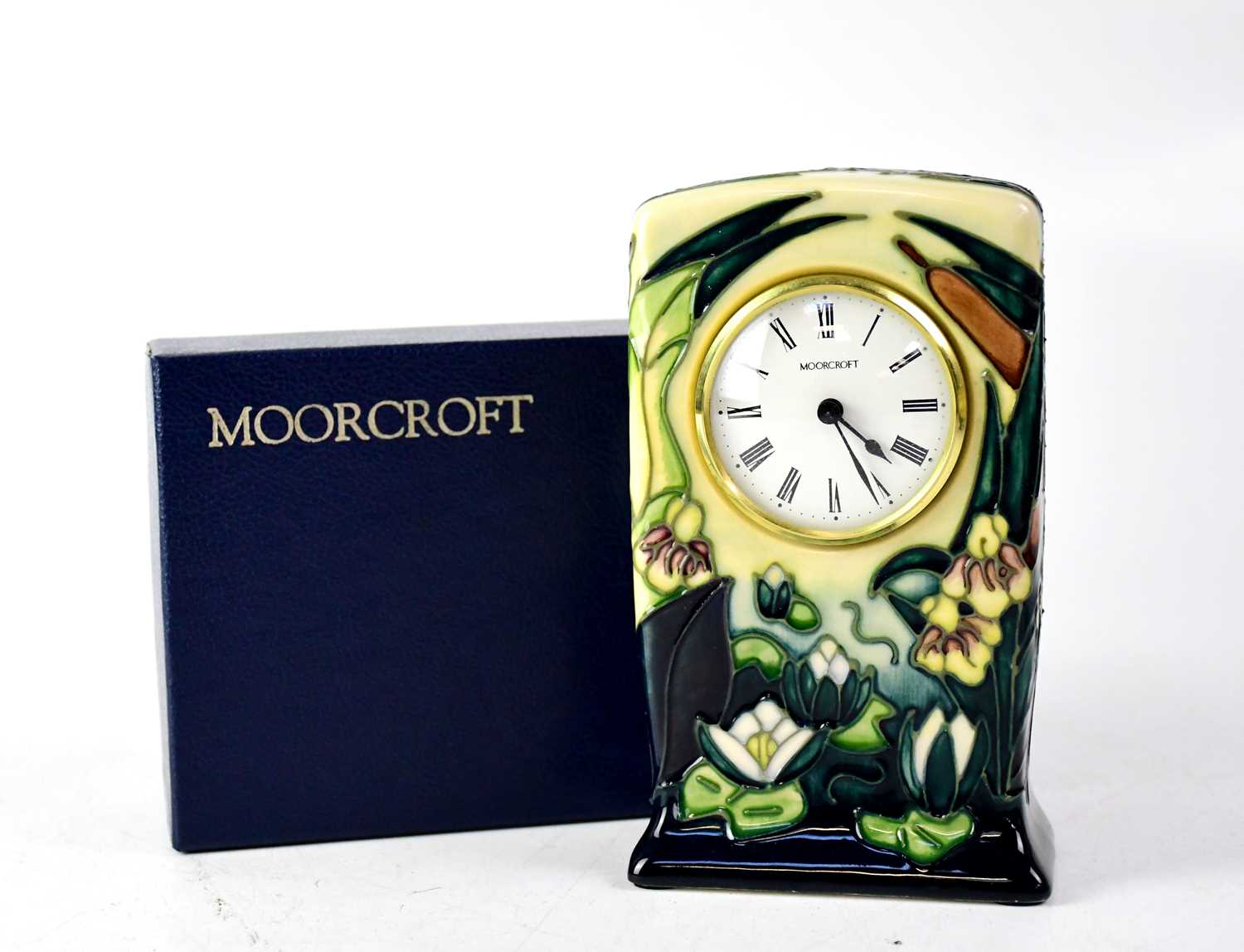 Lot 295 - MOORCROFT; a mantel clock with green and blue...