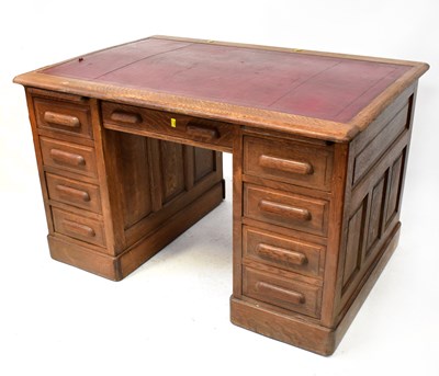 Lot 74 - An oak pedestal desk, with red leather inset...