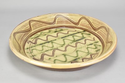 Lot 804 - A large slipware dish with combed meander...