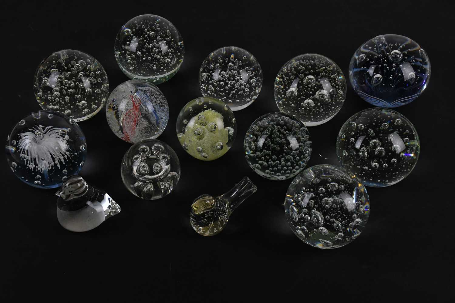 Lot 606 - A collection of twelve glass paperweights,