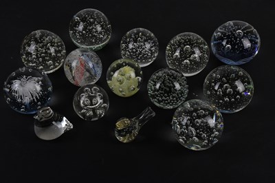 Lot 606 - A collection of twelve glass paperweights,...