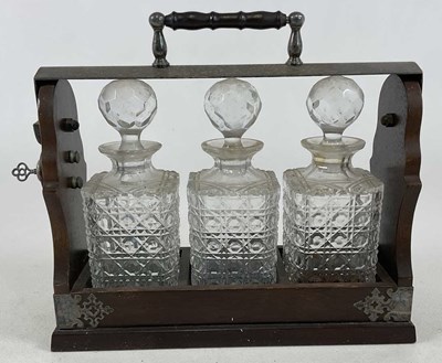 Lot 357 - An oak framed tantalus with three matching...