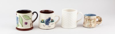 Lot 721 - A group of slipware and porcelain mugs by...