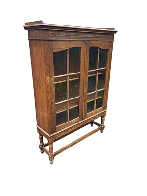 Lot 1244 - An early 20th century oak display cabinet with...