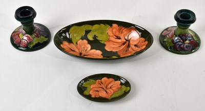 Lot 427 - MOORCROFT; four pieces comprising a pair of...